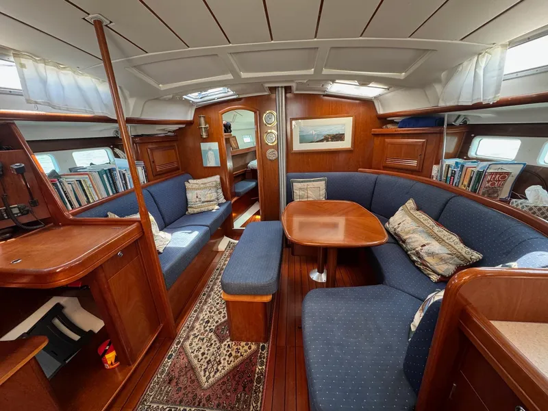 Slide: The Image of Interior of a 2005 Beneteau 423 sailboat with cozy seating and wooden finishes. - 21