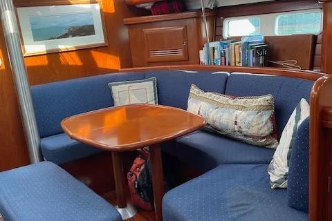 Slide: The Image of Interior of 2005 Beneteau 423 sailboat with cozy seating and wooden table. - 23