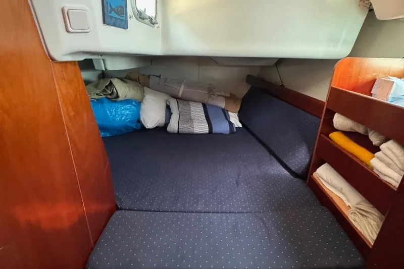 Slide: The Image of Cozy cabin interior of 2005 Beneteau 423 sailboat with bedding and storage shelves. - 28