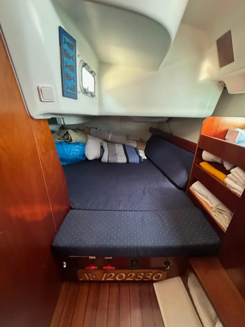 Slide: The Image of Cozy cabin interior of 2005 Beneteau 423 sailboat with bed and storage shelves. - 29