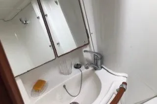 Slide: The Image of Bathroom sink area in a 2005 Beneteau 423 yacht, featuring a mirror and faucet. - 37