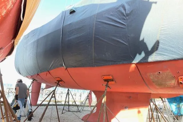 Slide: The Image of 2005 Beneteau 423 sailboat on stands, partially covered, in a boatyard setting. - 44