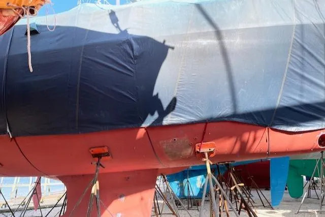 Slide: The Image of 2005 Beneteau 423 sailboat on stands, partially covered, in a boatyard. - 45