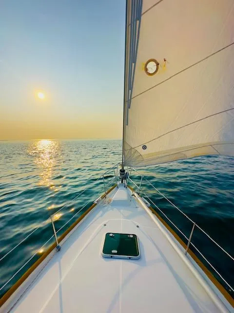 Slide: The Image of Sailing on a 2005 Beneteau 423 yacht at sunset over calm ocean waters. - 7