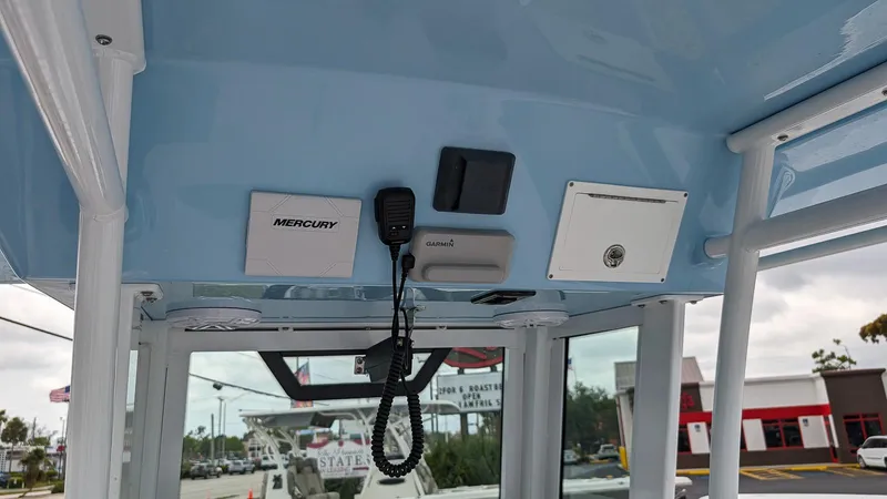 Slide: The Image of 2024 Wellcraft 263 Fisherman boat console with Mercury controls and communication equipment. - 11