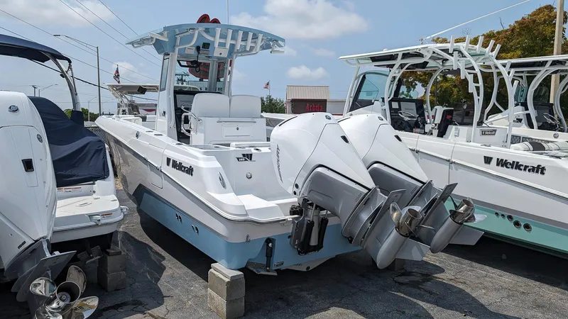 Slide: The Image of 2024 Wellcraft 263 Fisherman boat with twin outboard engines, docked at a marina. - 2