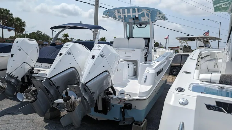 Slide: The Image of 2024 Wellcraft 263 Fisherman boat with dual outboard engines, docked at a marina. - 3