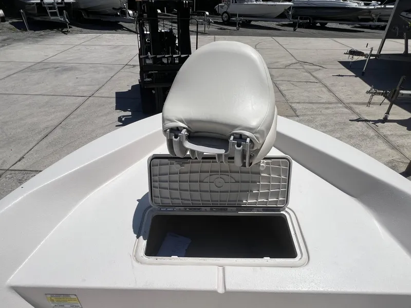 Slide: The Image of 2024 Carolina Skiff EV198 boat with open storage compartment and cushioned seat. - 18