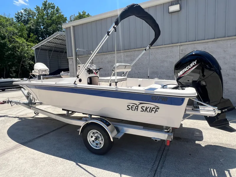 Slide: The Image of 2024 Carolina Skiff EV198 boat on trailer with Mercury outboard motor. - 2