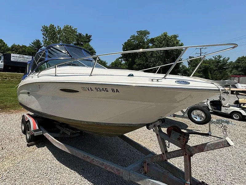 The Image of 2003 Sea Ray 225 Weekender boat on a trailer in a gravel lot. - 0