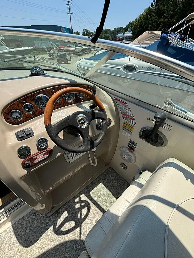 Slide: The Image of 2003 Sea Ray 225 Weekender boat cockpit with steering wheel and control panel. - 14