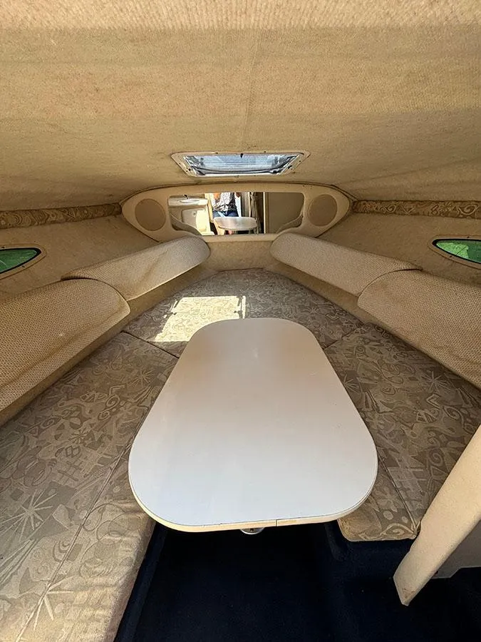 Slide: The Image of 2003 Sea Ray 225 Weekender cabin interior with table and seating. - 24