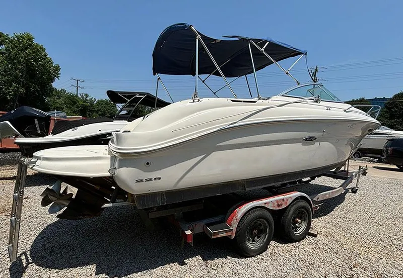 Slide: The Image of 2003 Sea Ray 225 Weekender boat on a trailer with a blue canopy. - 5