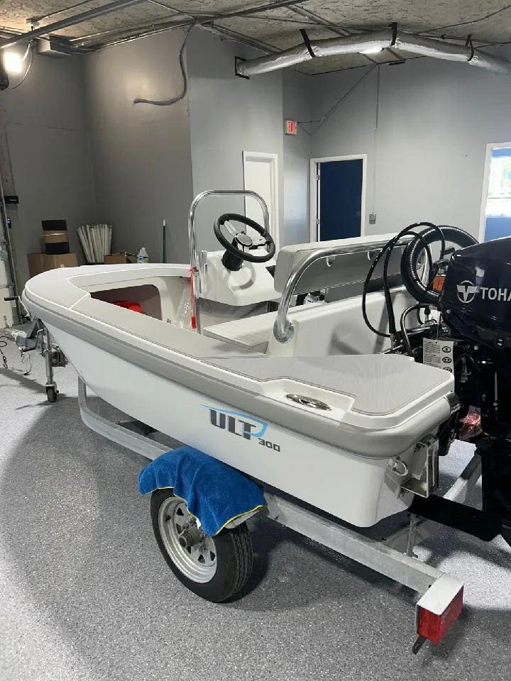 Slide: The Image of 2024 Ultra Lite Tenders Rigged 300 boat on trailer in indoor showroom. - 1