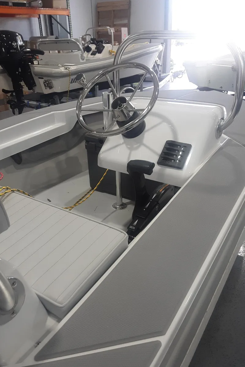 Slide: The Image of 2024 Ultra Lite Tenders Rigged 300 boat interior with steering wheel and seating. - 4