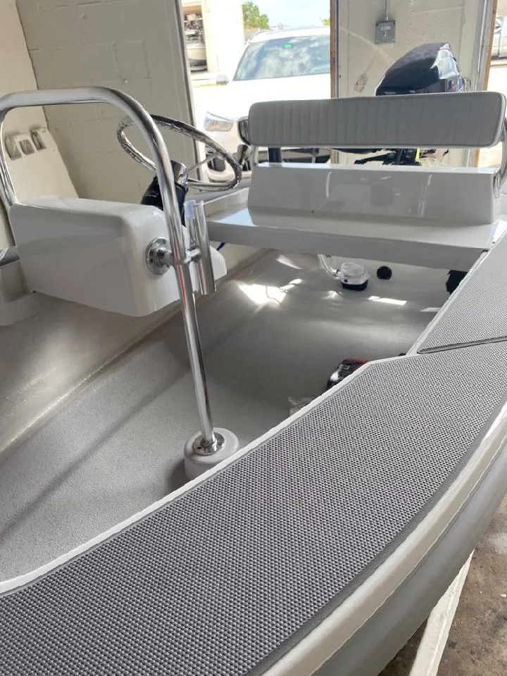 Slide: The Image of 2024 Ultra Lite Tenders Rigged 300 boat interior with steering console and seating. - 8