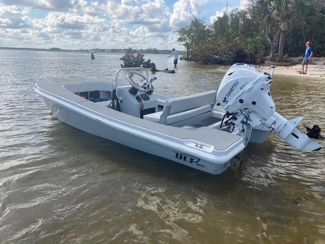 Slide: The Image of 2024 Ultra Lite Tenders Rigged 380 boat docked near a sandy shore. - 13