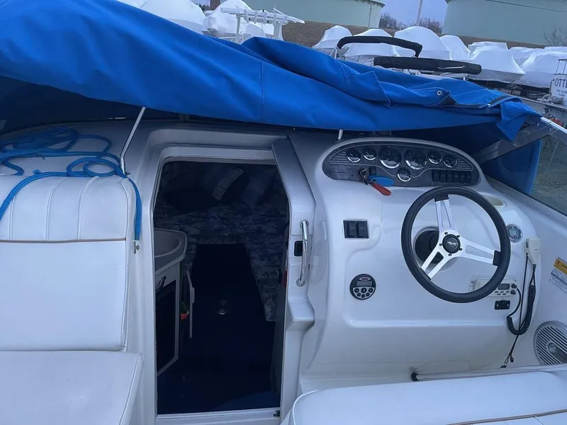 Slide: The Image of 1998 Sea Ray 240 Sundancer boat interior with white seating and steering wheel. - 11