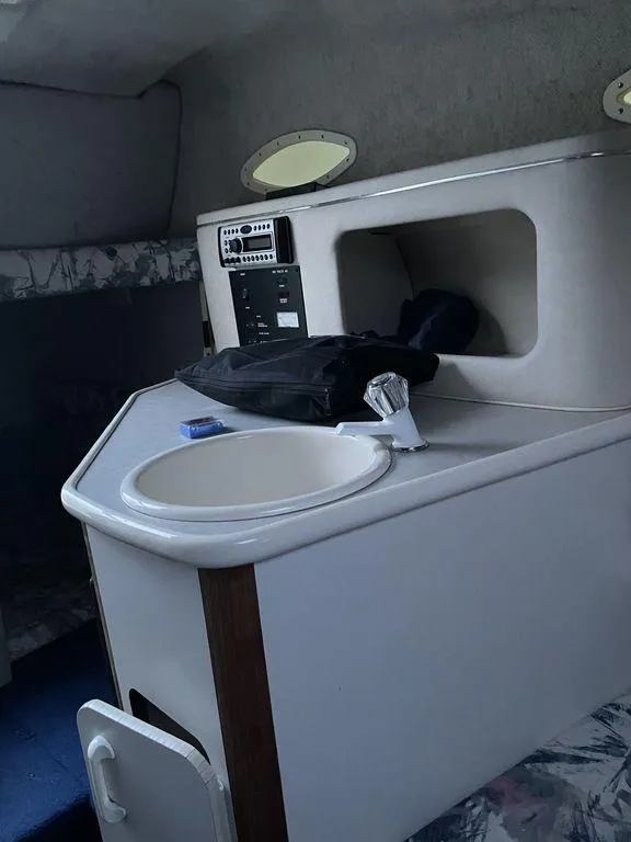 Slide: The Image of 1998 Sea Ray 240 Sundancer boat interior seating area in white upholstery. - 14