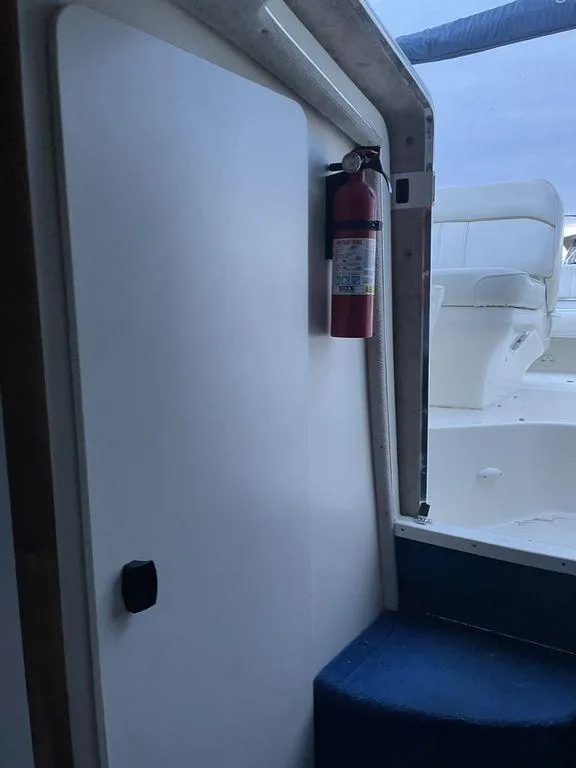 Slide: The Image of 1998 Sea Ray 240 Sundancer cabin interior with compact marine toilet. - 22