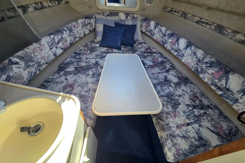 Slide: The Image of 1998 Sea Ray 240 Sundancer cabin interior with patterned seating and table. - 26