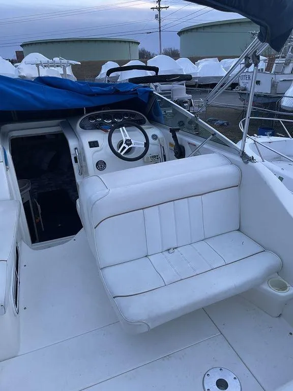 Slide: The Image of 1998 Sea Ray 240 Sundancer boat on trailer, parked in urban setting. - 6