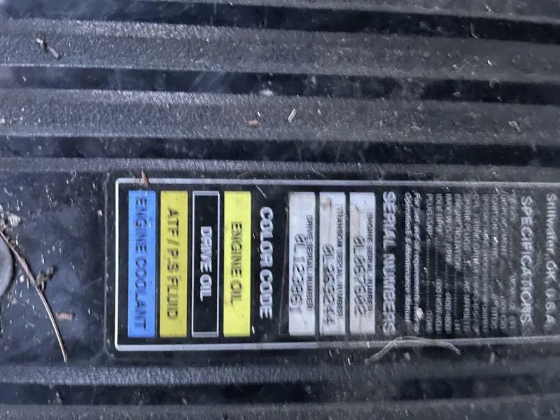 Slide: The Image of 1998 Sea Ray 240 Sundancer boat stern with propeller and trailer, parked outdoors. - 9