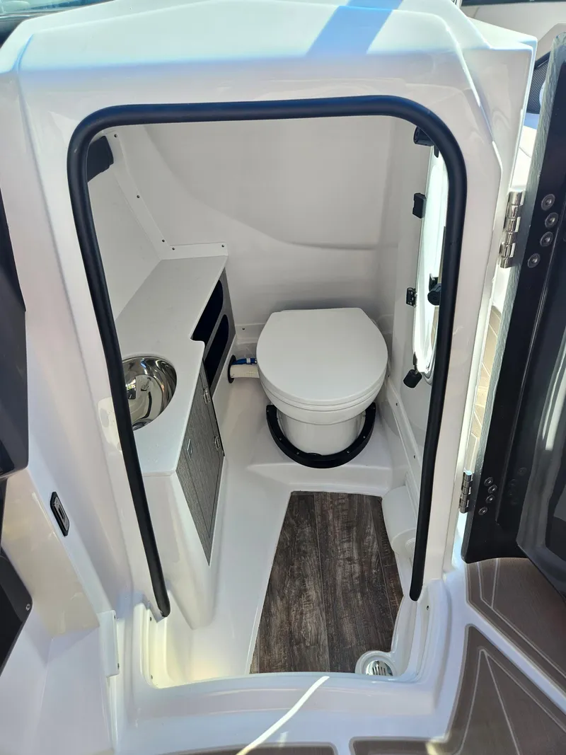 Slide: The Image of 2025 Monterey 275SS boat interior bathroom with toilet and sink. - 23