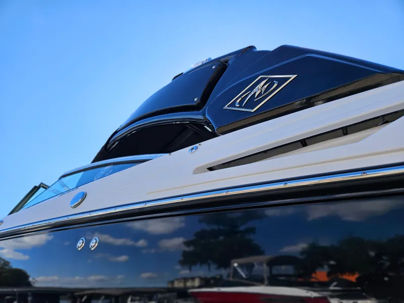 Slide: The Image of 2025 Monterey 275SS boat with sleek black and white design against a clear blue sky. - 40