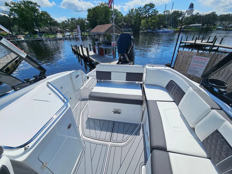 Slide: The Image of 2025 Monterey M-65 boat interior with seating, docked by a scenic waterfront. - 11