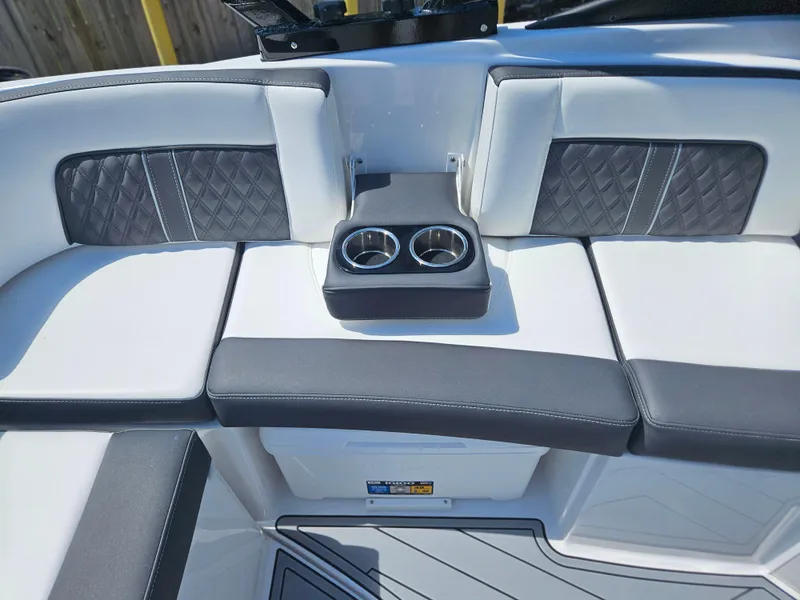Slide: The Image of 2025 Monterey M-65 boat interior with cushioned seating and dual cup holders. - 12