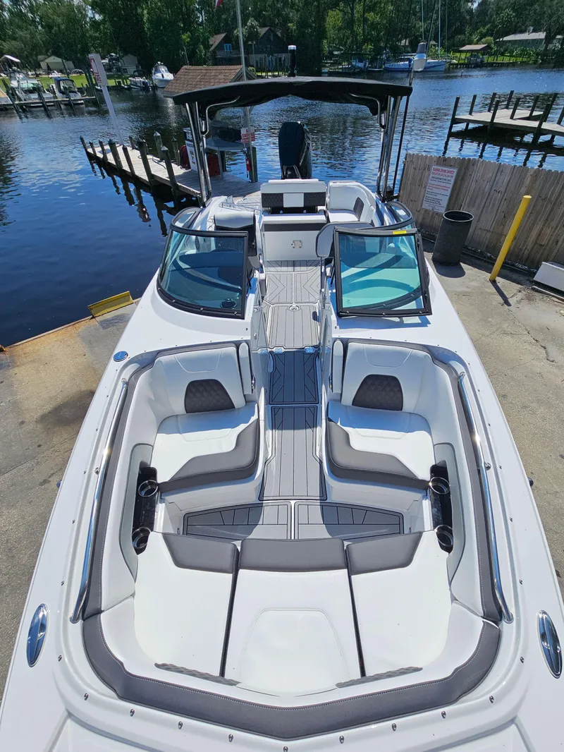 Slide: The Image of 2025 Monterey M-65 boat docked by a serene waterfront, showcasing sleek design and spacious seating. - 31