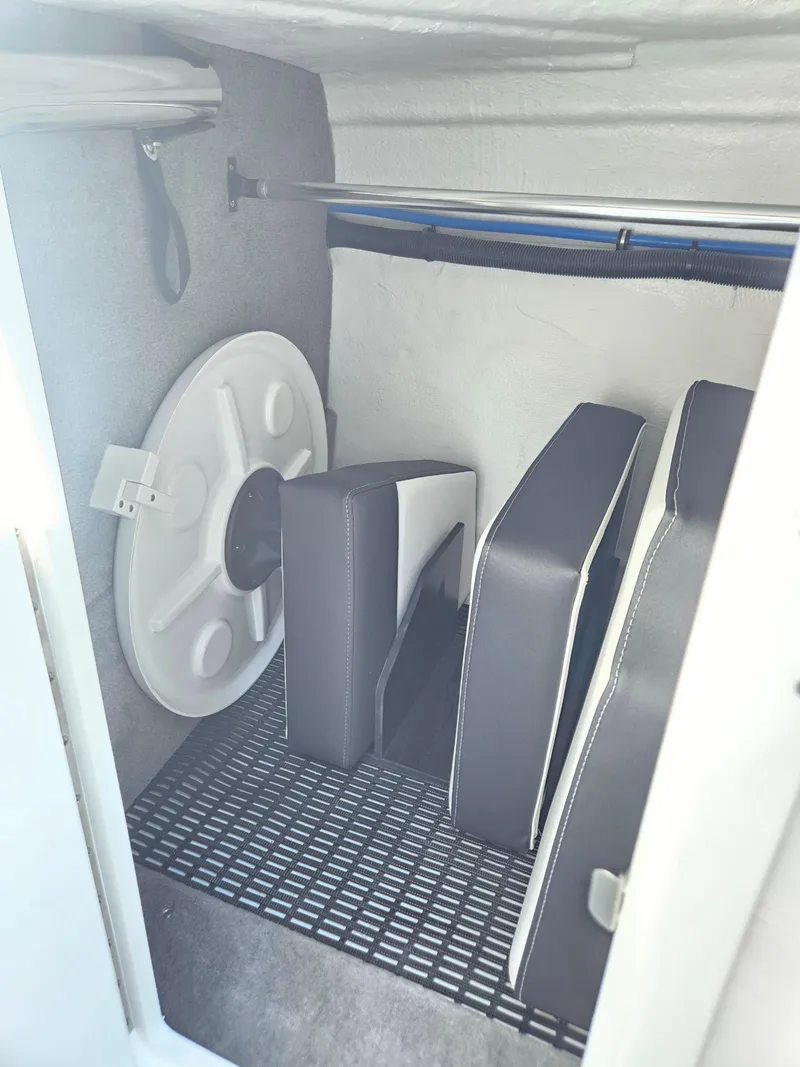 Slide: The Image of Storage compartment in a 2025 Monterey M-65 boat with cushions and a life preserver. - 32