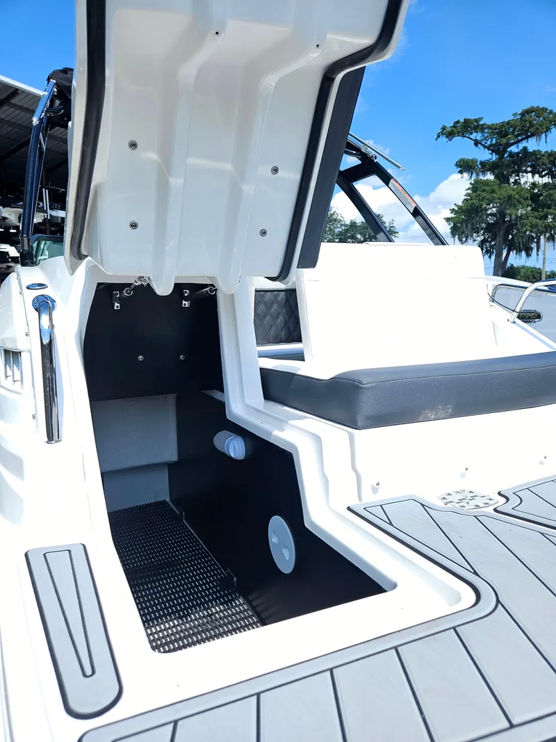 Slide: The Image of 2025 Monterey M-65 boat interior, open storage compartment, sleek design, white and gray color scheme. - 38