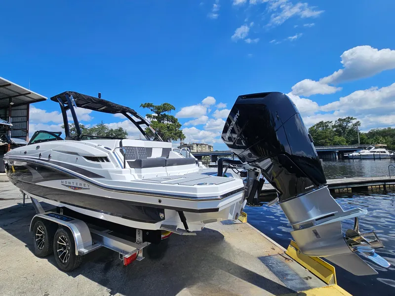 Slide: The Image of 2025 Monterey M-65 boat on trailer by waterfront, under clear blue sky. - 4