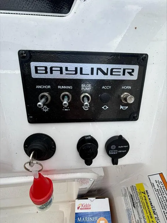 Slide: The Image of Control panel of a 2023 Bayliner 170 EL boat with switches and key. - 10