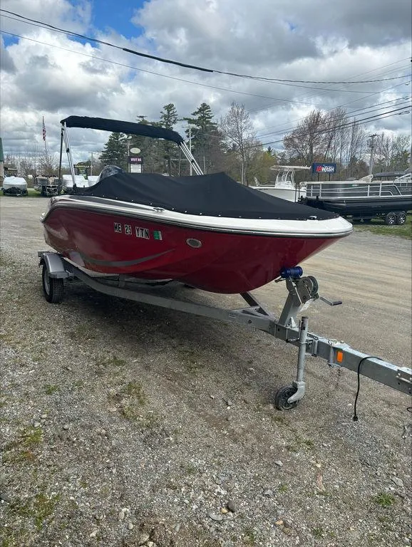 Slide: The Image of 2023 Bayliner 170 EL boat on trailer with cover, parked outdoors. - 2
