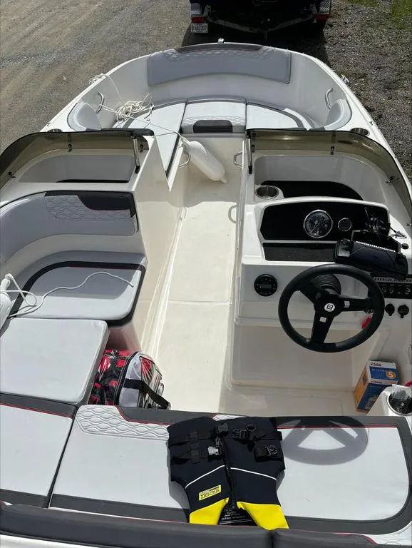 Slide: The Image of 2023 Bayliner 170 EL boat interior with seating, steering wheel, and storage compartments. - 6