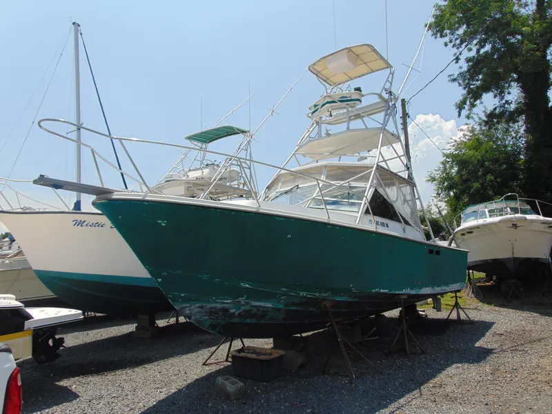 Slide: The Image of 1987 Black Watch Sportfish boat on dry dock, surrounded by other vessels. - 10