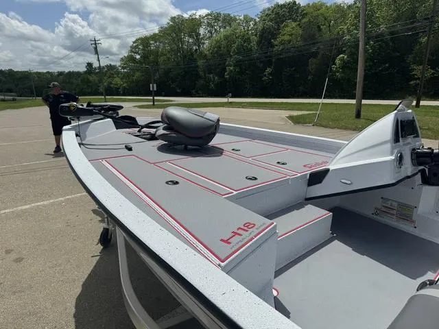 Slide: The Image of 2024 Xpress Boats H18 model, parked on a sunny day, showcasing its deck and seating. - 13
