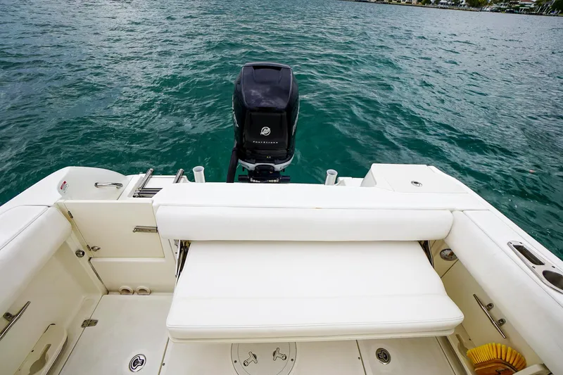 Slide: The Image of 2015 Boston Whaler 220 Outrage boat stern view with outboard motor. - 11