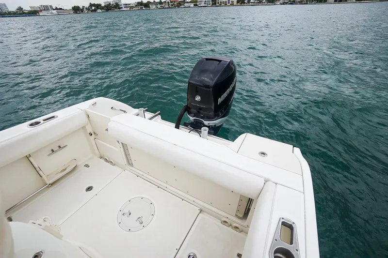Slide: The Image of 2015 Boston Whaler 220 Outrage boat stern with outboard motor on water. - 14