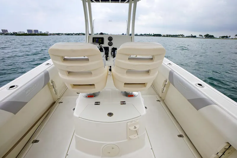 Slide: The Image of 2015 Boston Whaler 220 Outrage boat interior with dual captain seats on open water. - 15