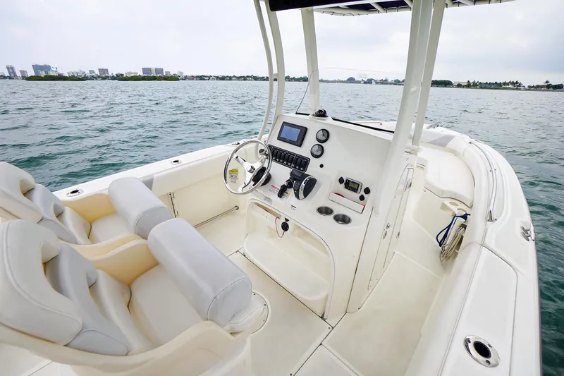 Slide: The Image of 2015 Boston Whaler 220 Outrage boat interior with helm and seating on the water. - 18