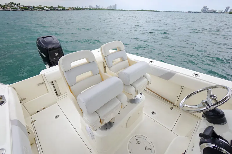 Slide: The Image of 2015 Boston Whaler 220 Outrage boat interior with twin seats and steering wheel. - 19
