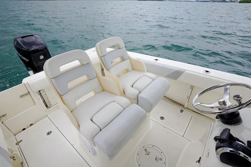 Slide: The Image of 2015 Boston Whaler 220 Outrage boat interior with dual seats and steering wheel. - 20