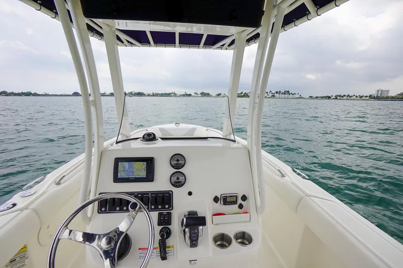 Slide: The Image of Boston Whaler 220 Outrage 2015 boat console with steering wheel and navigation system on open water. - 22
