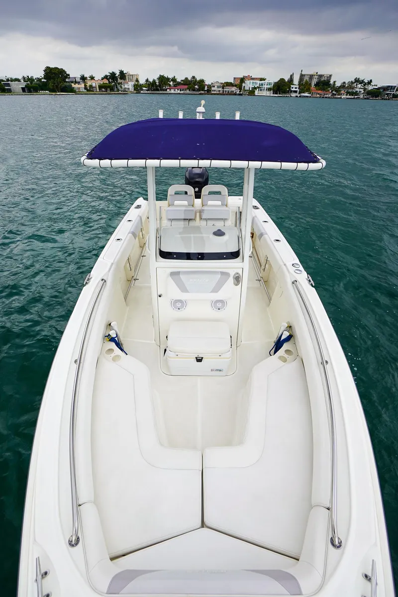 Slide: The Image of 2015 Boston Whaler 220 Outrage boat with blue canopy on open water. - 26