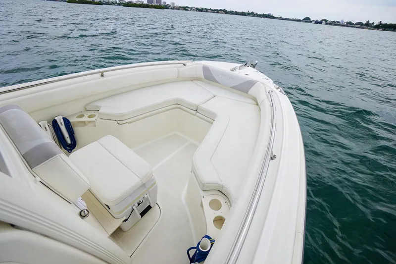 Slide: The Image of 2015 Boston Whaler 220 Outrage boat interior with cushioned seating on the water. - 27