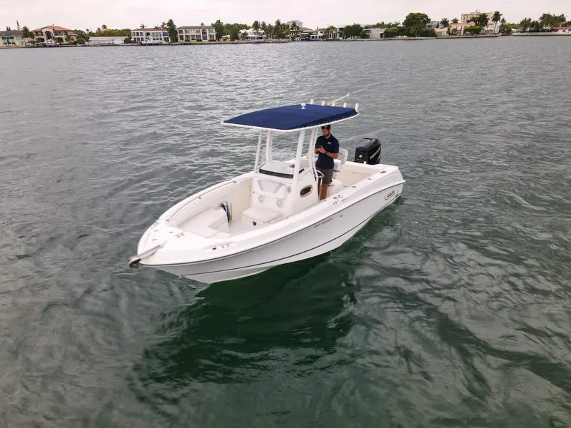 Slide: The Image of 2015 Boston Whaler 220 Outrage boat on water with blue canopy. - 4
